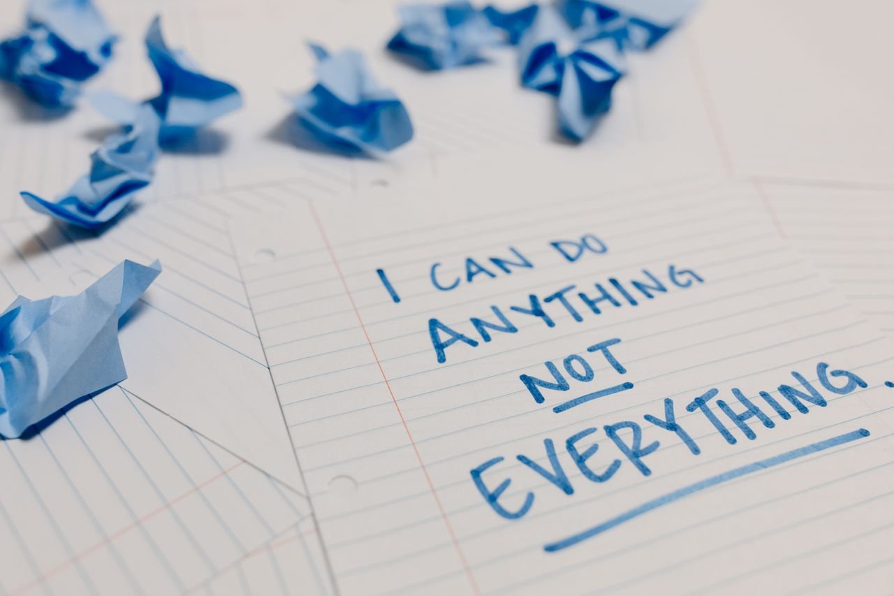 Handwritten motivational quote on lined paper with crumpled notes around, emphasizing self-empowerment.